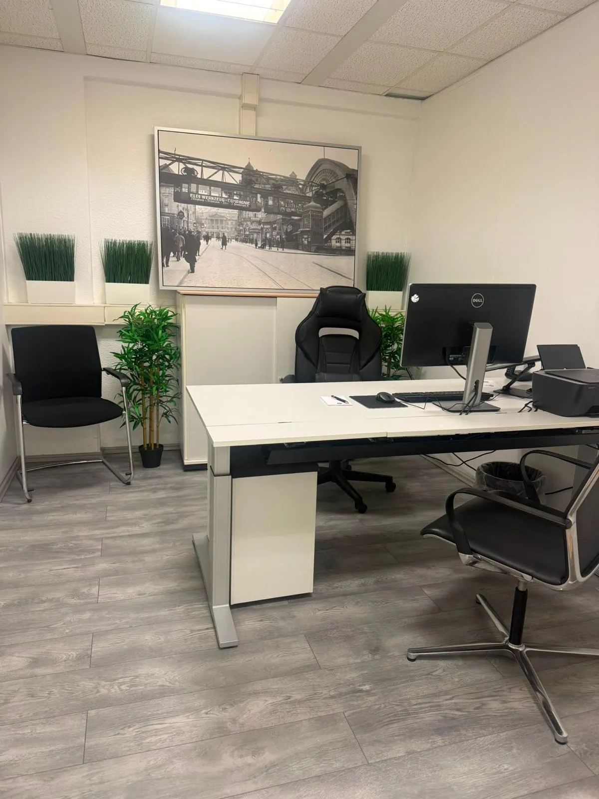 Ausgestattetes Einzelbüro mit Schreibtisch und Besucherplätzen